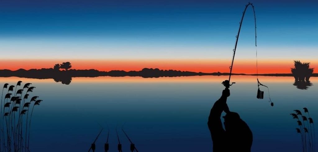 Carp angler making a long-distance cast with a casting rod at sunrise over a big open lake