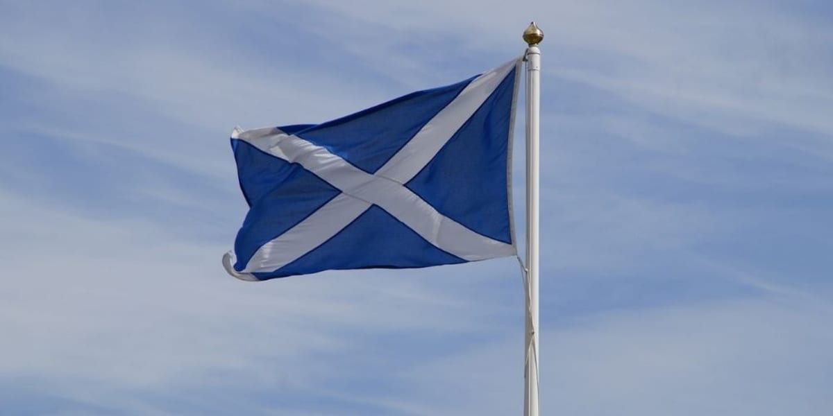 The Scottish Saltire flag flying against a clear blue sky