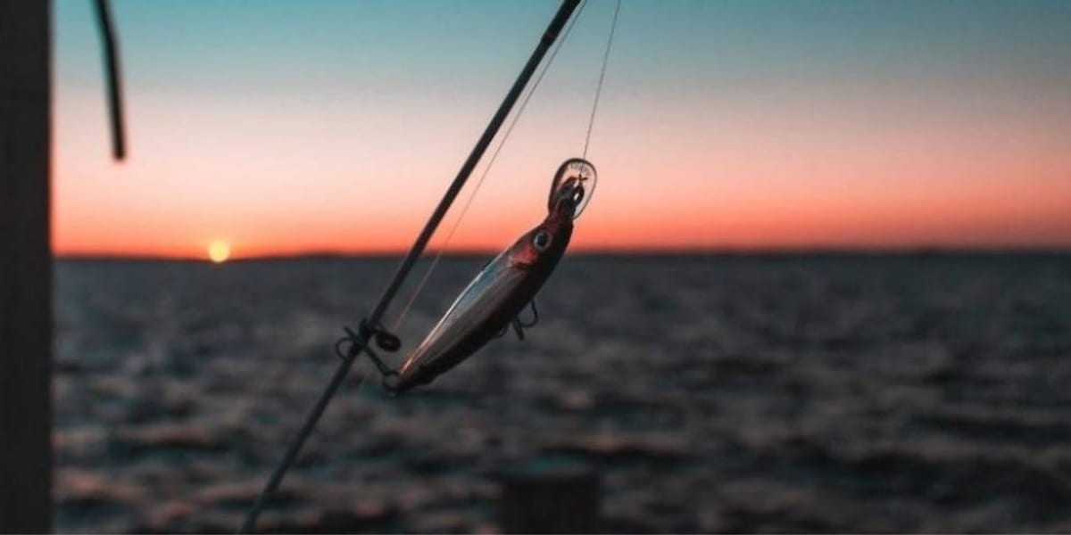 A flat-lay of assorted sea fishing lures including metal casting lures and soft sandeels